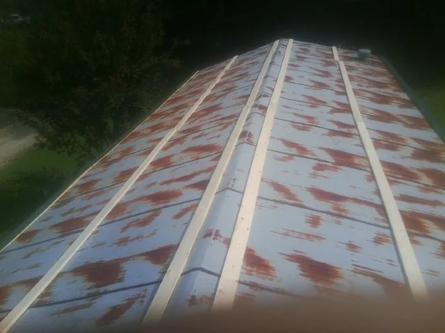 Rusted metal roof panels with new wood purlins before replacement — Storm Damage Roof Repair in Star City by Roofing Brothers