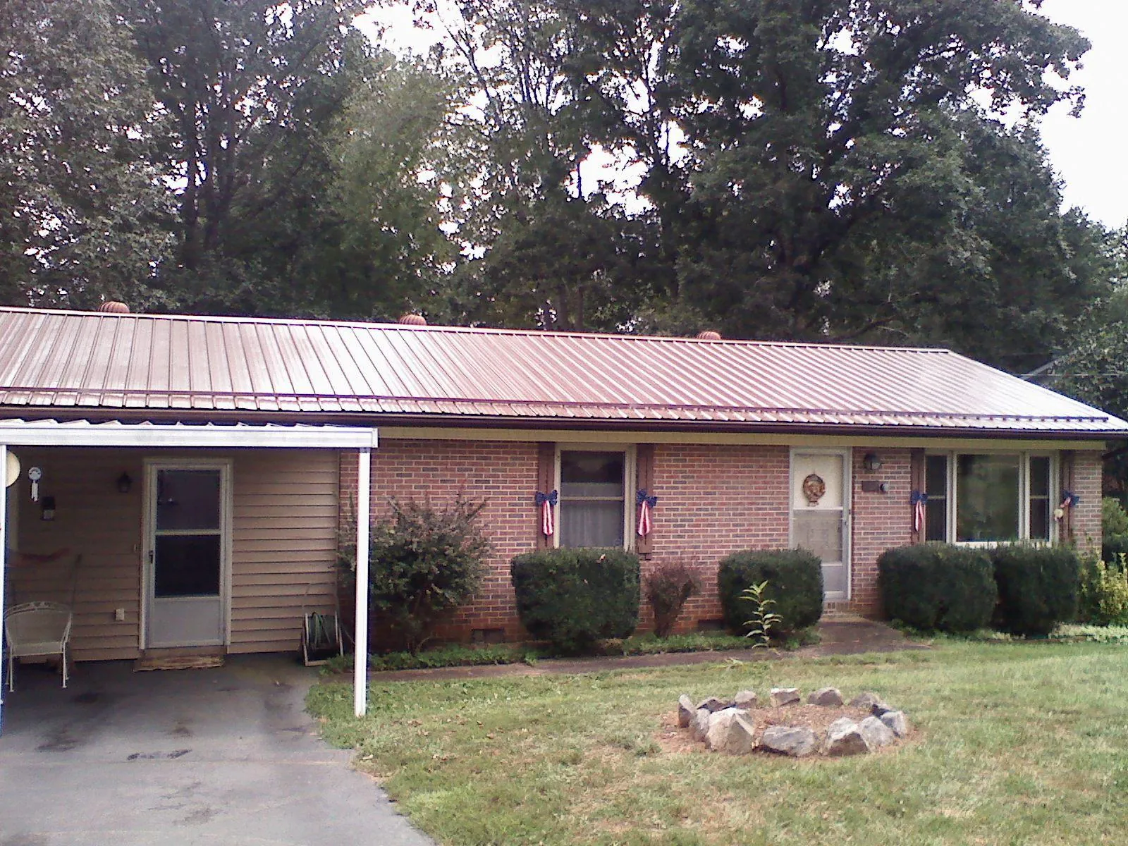 Bronze metal roof and carport on a brick ranch home — Roof Repair work by our crew in Star City